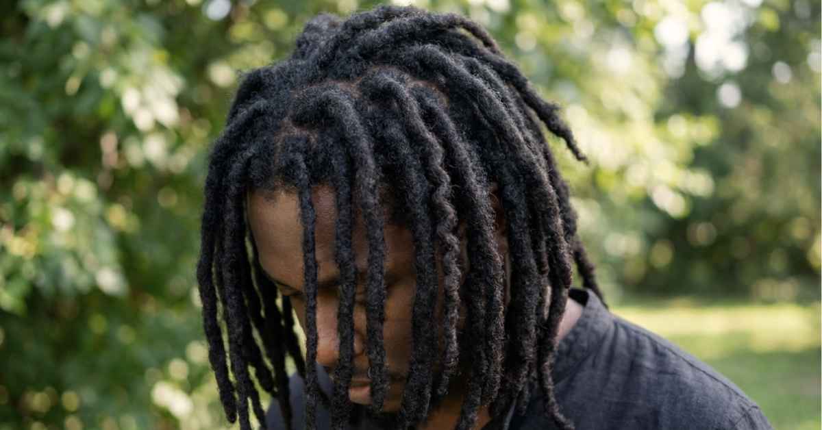 Close up of type 4c hair with two year old freeform locs, thick and deeply textured with dramatic shape variation